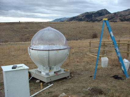 Using weighted bucket to apply simulated wind force to inflatable heliostat